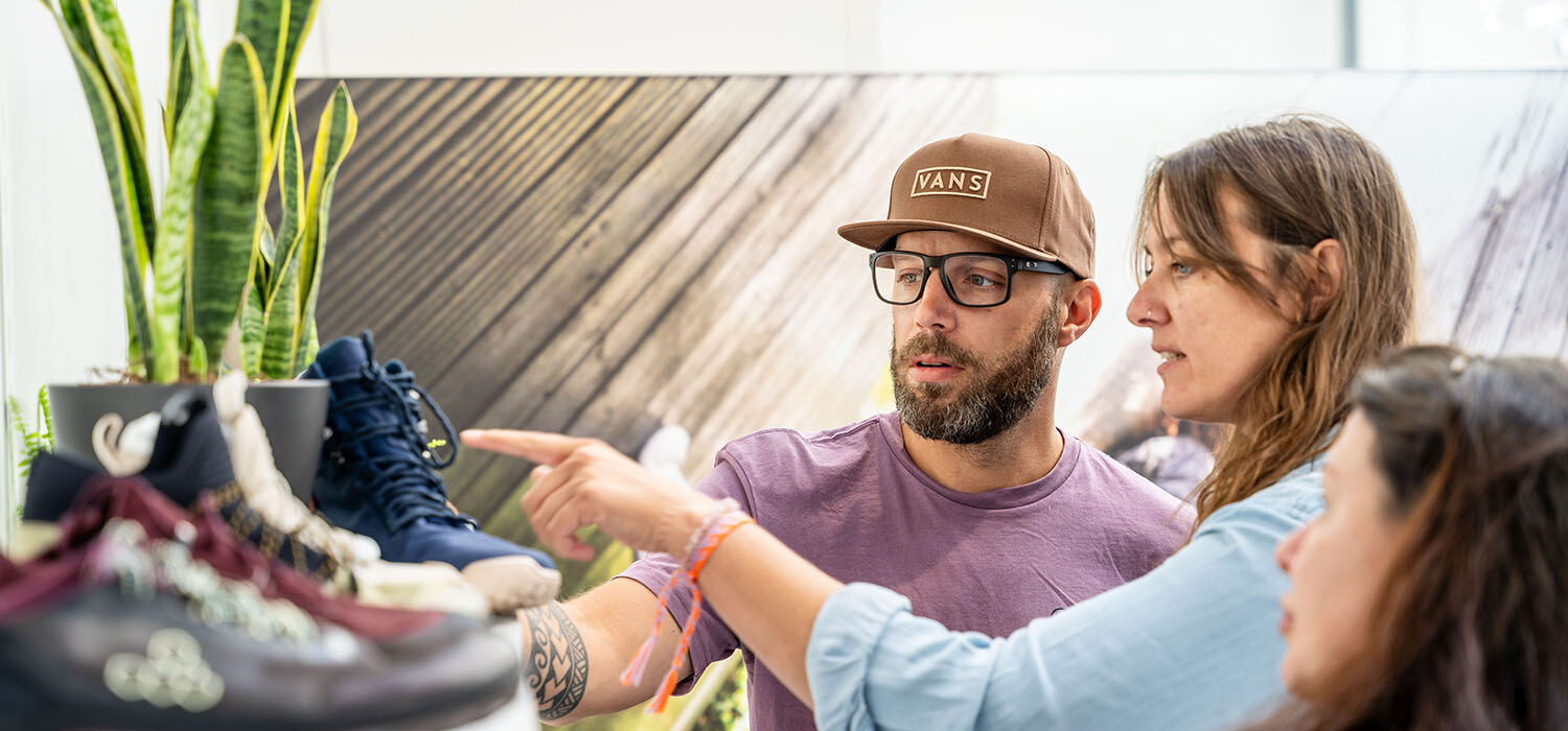 Visitors discussing shoes with an exhibitor at a footwear stand, photo by Messe Offenbach / Esra Klein